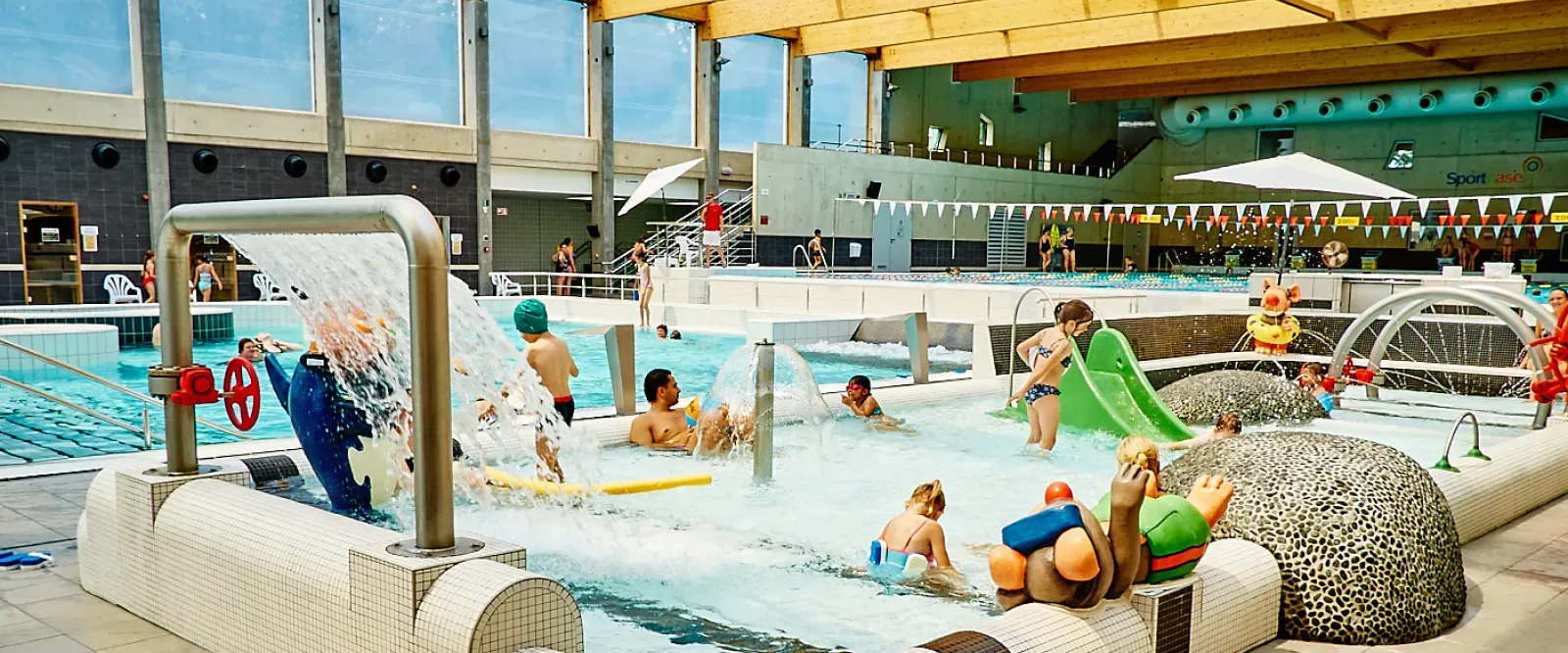 Kinderen genieten van de glijbanen in het subtropisch zwemparadijs van Sportoase
